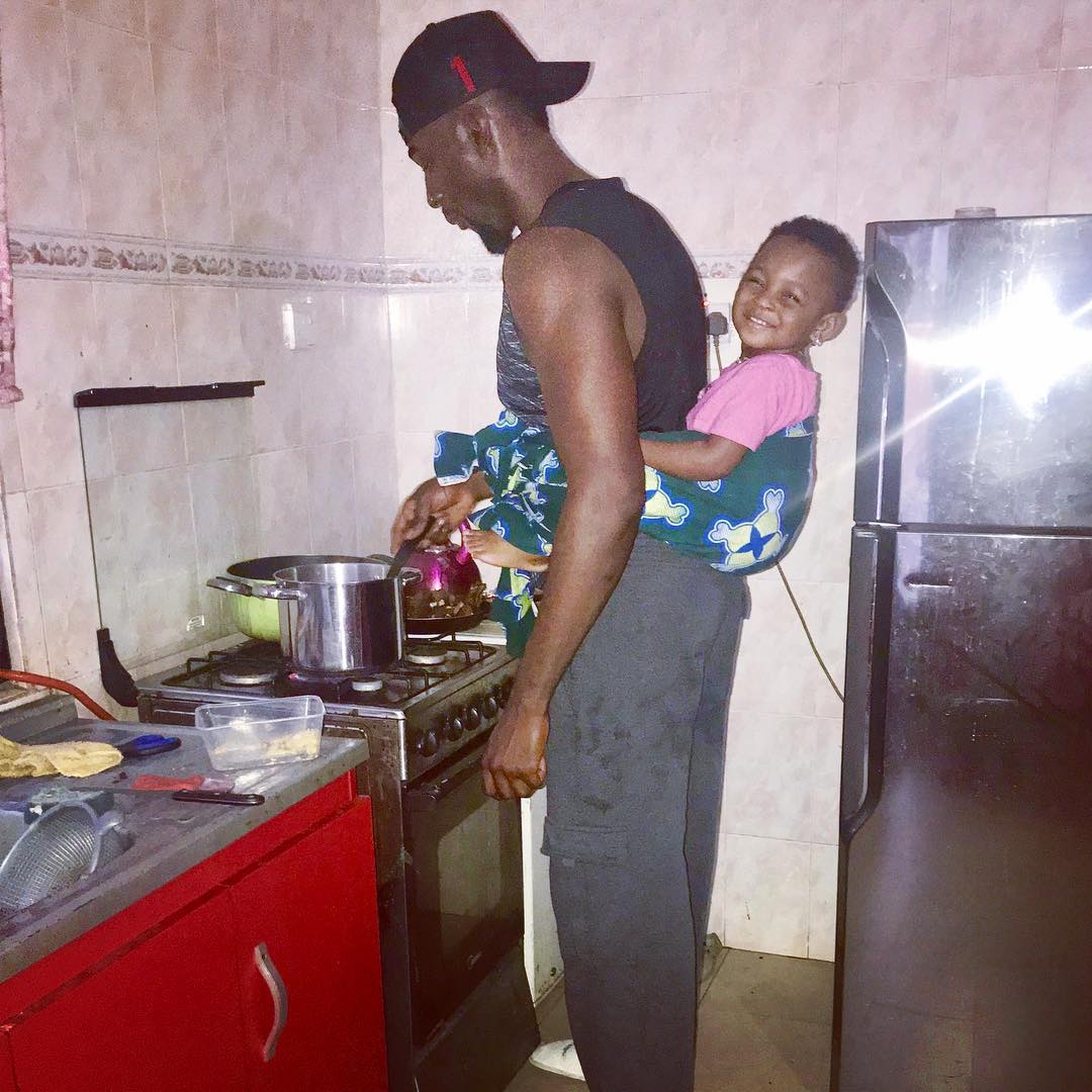 Gbenro Ajibade Pictured Cooking With Baby Strapped On His Back (2)