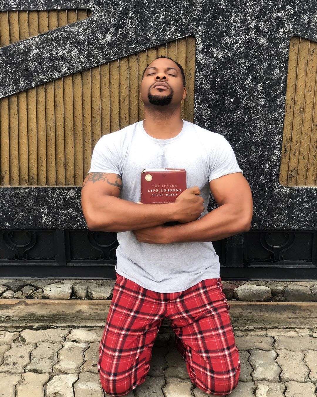 Photo Of Bolanle Ninalowo On Knees With Bible On His Chest (2)